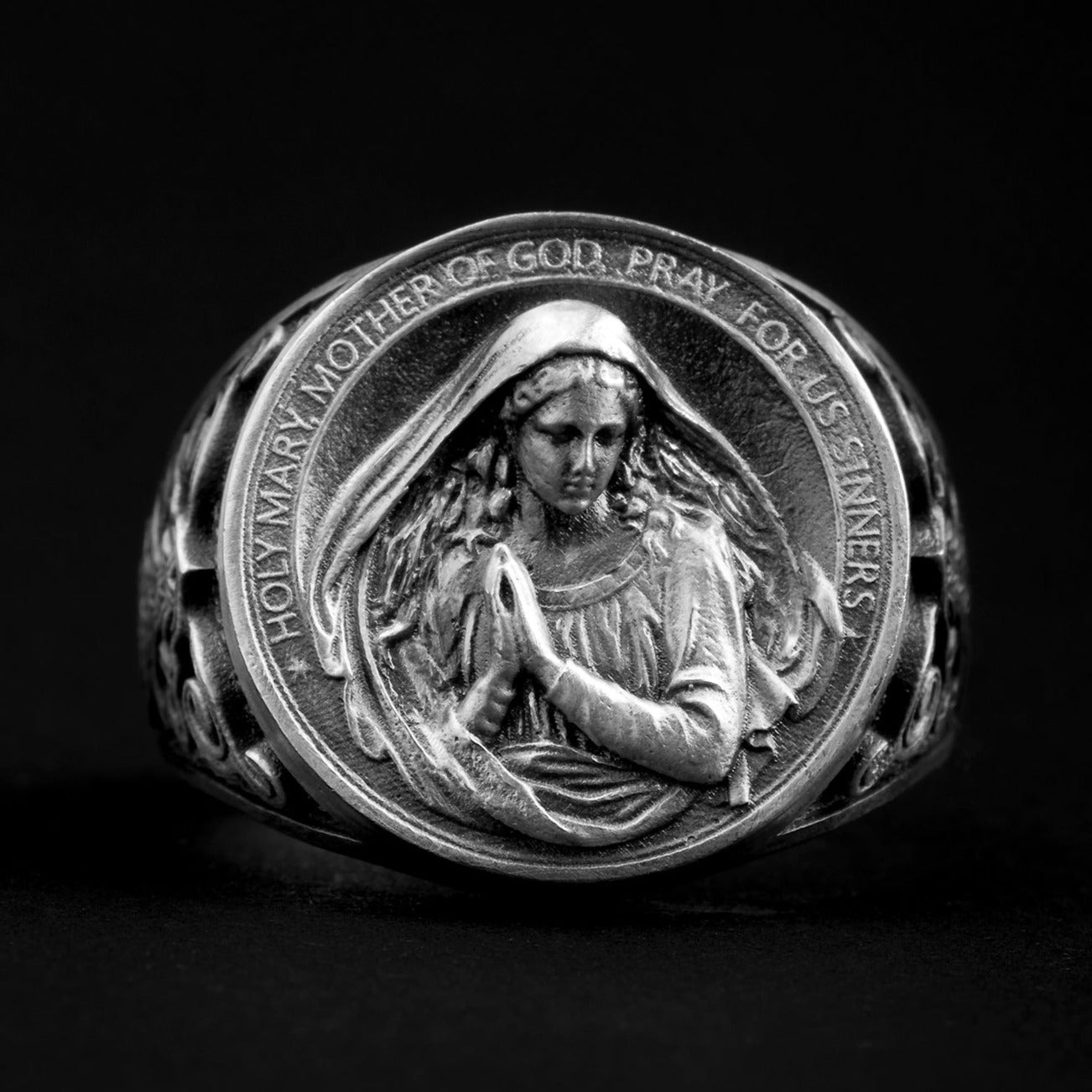Sterling silver Virgin Mary Ring showcasing intricately engraved Mary with folded hands and the prayer 'Holy Mary, Mother of God, Pray for us sinners' encircling the design.