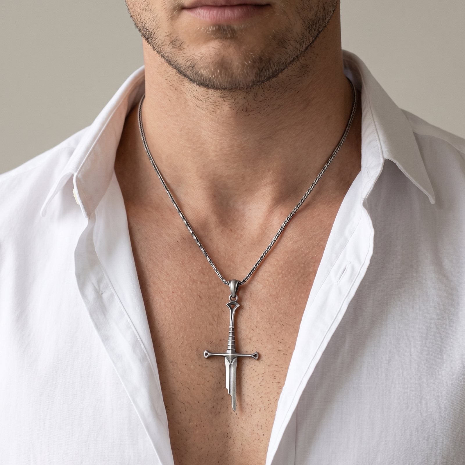 Man wearing the oxidized silver Elven Sword pendant necklace, open white shirt