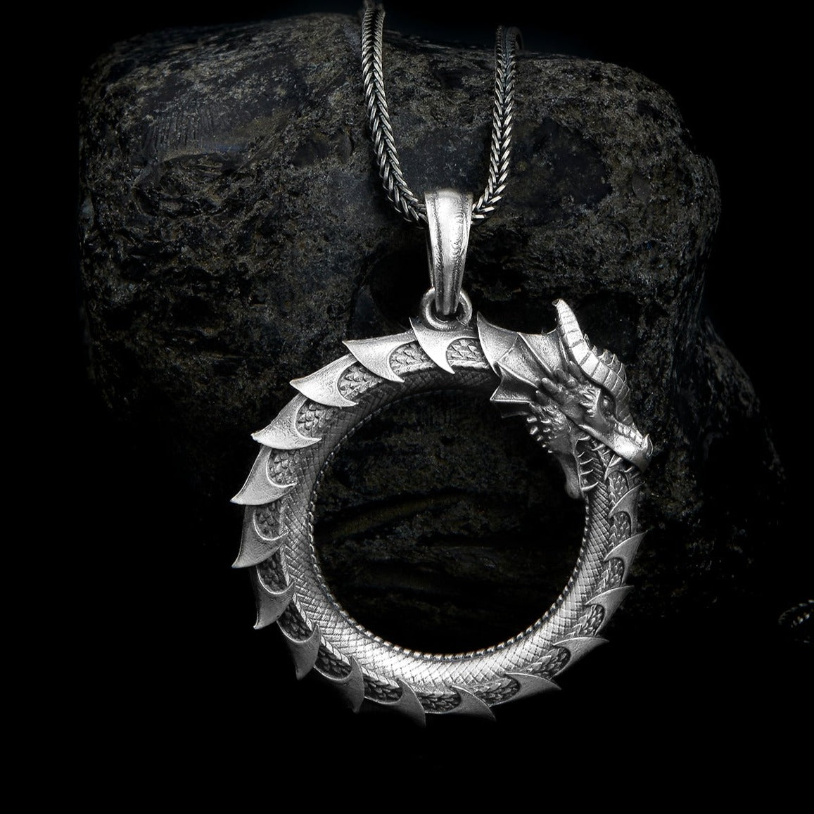 Handcrafted sterling silver necklace showcasing a meticulously detailed Ouroboros, a symbol of eternity, on a delicate chain.