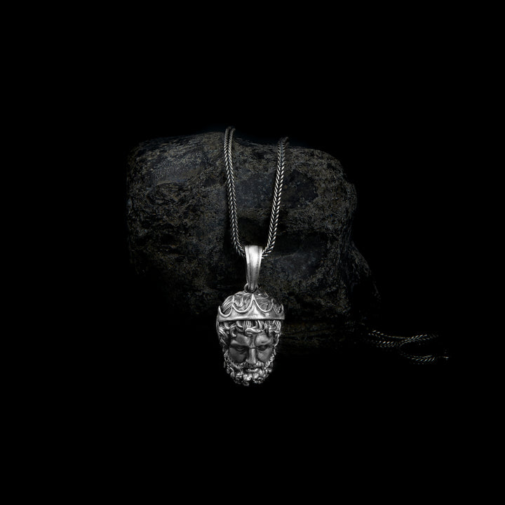 Sterling silver pendant necklace showcasing a detailed carving of Poseidon's face, adorned with a crown and accentuated by intricately designed hair and beard.